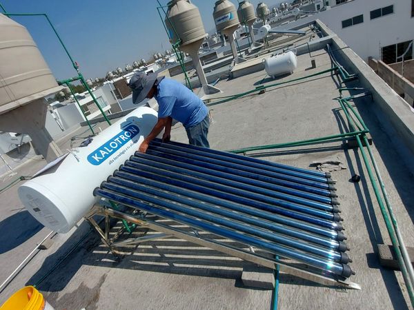 Técnico de I Green montando los tubos de un calentador solar en una azotea de San Luis Potosí